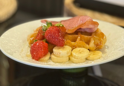 Waffles with bacon, strawberries and bananas